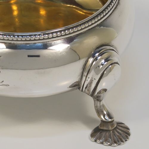 A large and handsome pair of Antique Victorian Sterling Silver salt cellars, having plain round bellied bodies, with gold-gilt interiors, applied shaped bead-edged top borders, and all sitting on three cast shell feet with reeded shoulders. These elegant silver salt cellars were made by Alfred Ivory of London in 1861. The dimensions of these fine hand-made antique silver salt cellars are diameter 7.5 cms (3 inches), height 4 cms (1.5 inches), and they weigh a total of approx. 155g (5 troy ounces). Please note that these items are crested.