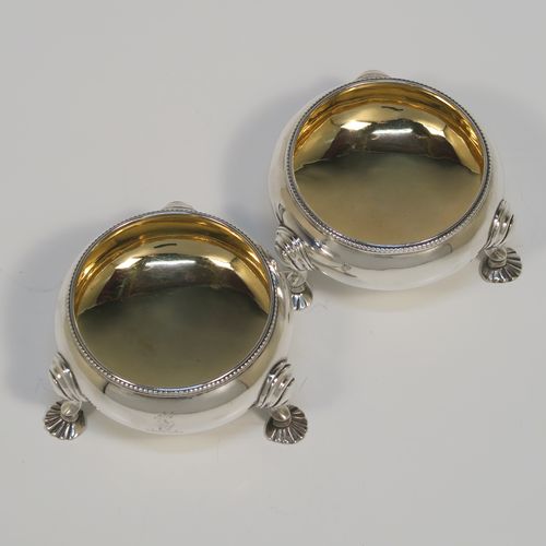 A large and handsome pair of Antique Victorian Sterling Silver salt cellars, having plain round bellied bodies, with gold-gilt interiors, applied shaped bead-edged top borders, and all sitting on three cast shell feet with reeded shoulders. These elegant silver salt cellars were made by Alfred Ivory of London in 1861. The dimensions of these fine hand-made antique silver salt cellars are diameter 7.5 cms (3 inches), height 4 cms (1.5 inches), and they weigh a total of approx. 155g (5 troy ounces). Please note that these items are crested.