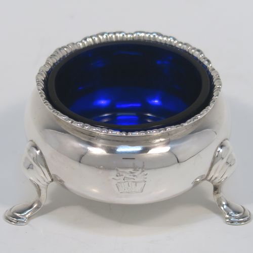 A very handsome pair of Antique Victorian Sterling Silver salt cellars, having plain round bellied bodies, with blue-glass liners, applied shaped gadroon borders, and all sitting on three cast hoof feet with reeded shoulders. These elegant silver salt cellars were made by Francis Boone Thomas of London in 1874. The dimensions of these fine hand-made antique silver salt cellars are diameter 6.5 cms (2.5 inches), height 4 cms (1.5 inches), and they weigh a total of approx. 128g (4 troy ounces).
