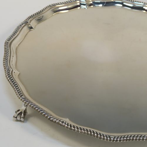 A very elegant Antique Edwardian Sterling Silver salver, having an applied Gadroon border, a plain ground, and sitting on four cast claw and ball feet. This handsome antique silver salver was made by Goldsmiths and Silversmiths of London in 1910. The dimensions of this fine hand-made silver salver are diameter 30.5 cms (12 inches), and it weighs approx. 878g (28 troy ounces).