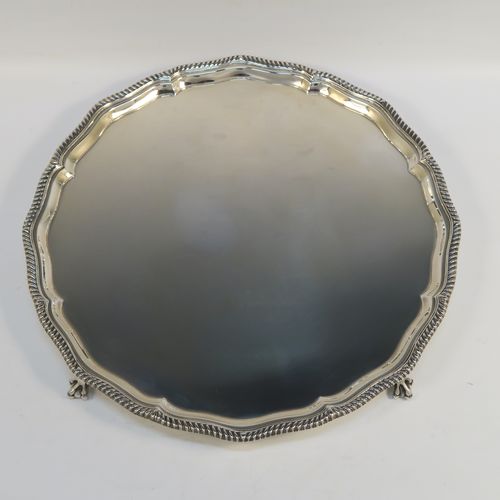 A very elegant Antique Edwardian Sterling Silver salver, having an applied Gadroon border, a plain ground, and sitting on four cast claw and ball feet. This handsome antique silver salver was made by Goldsmiths and Silversmiths of London in 1910. The dimensions of this fine hand-made silver salver are diameter 30.5 cms (12 inches), and it weighs approx. 878g (28 troy ounces).