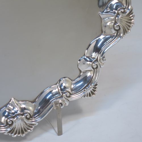 A very elegant Antique Georgian Sterling Silver salver, having an applied shell and scroll border, a plain ground, and sitting on three cast hoof feet. Made by Richard Rugg of London in 1760. The dimensions of this fine hand-made antique silver salver are diameter 33 cms (13 inches), height 4 cms (1.5 inches), and it weighs approx. 875g (28 troy ounces)