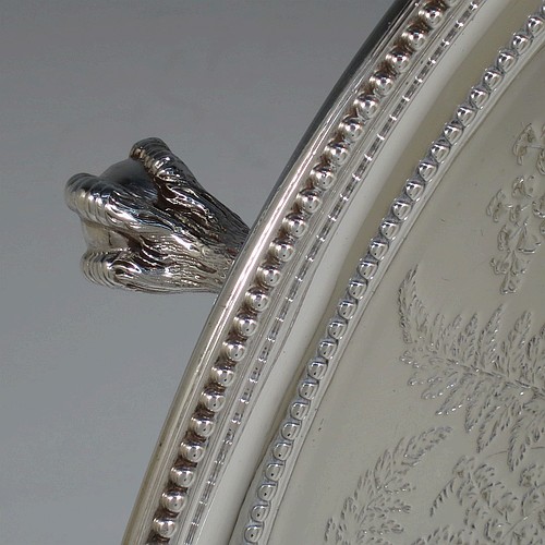 A very pretty Antique Victorian Sterling Silver large salver, having an applied double bead-edged border, with a ground having hand-engraved ferns and song-bird decoration surrounding a central vacant round cartouche, and all sitting on four cast claw and ball feet. Made by Johnson, Walker, and Tolhurst of London in 1881. The dimensions of this fine hand-made antique silver salver are diameter 38 cms (15 inches), and it weighs approx. 1,615g (52 troy ounces).