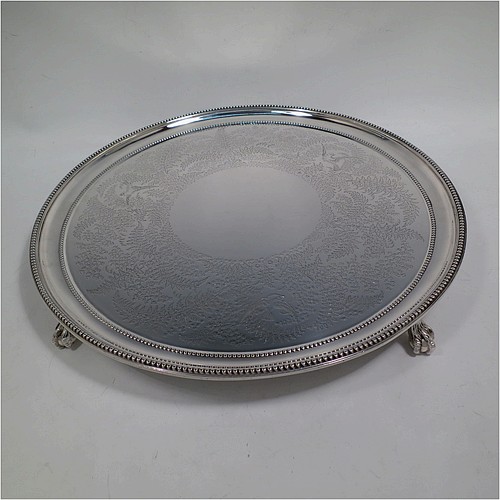 A very pretty Antique Victorian Sterling Silver large salver, having an applied double bead-edged border, with a ground having hand-engraved ferns and song-bird decoration surrounding a central vacant round cartouche, and all sitting on four cast claw and ball feet. Made by Johnson, Walker, and Tolhurst of London in 1881. The dimensions of this fine hand-made antique silver salver are diameter 38 cms (15 inches), and it weighs approx. 1,615g (52 troy ounces).