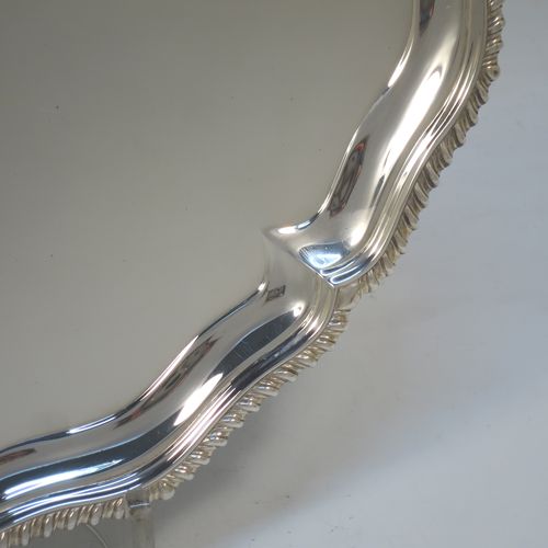 A very handsome Antique Edwardian Sterling Silver salver, having an applied shaped gadroon border, a plain ground, and sitting on three cast hoof feet. This elegant antique silver salver was made in London in 1904. The dimensions of this fine hand-made antique silver salver are diameter 33 cms (13 inches), and it weighs approx. 1,140g (37 troy ounces).