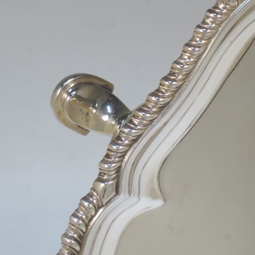 A very handsome Antique Edwardian Sterling Silver salver, having an applied shaped gadroon border, a plain ground, and sitting on three cast hoof feet. This elegant antique silver salver was made in London in 1904. The dimensions of this fine hand-made antique silver salver are diameter 33 cms (13 inches), and it weighs approx. 1,140g (37 troy ounces).