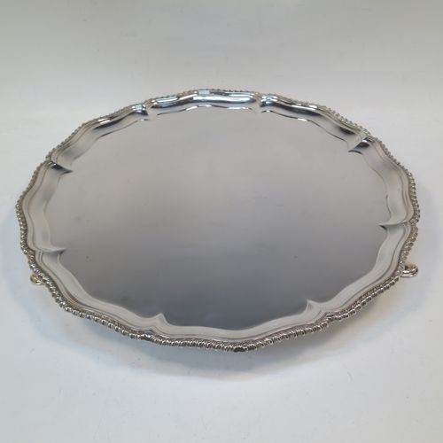 A very handsome Antique Edwardian Sterling Silver salver, having an applied shaped gadroon border, a plain ground, and sitting on three cast hoof feet. This elegant antique silver salver was made in London in 1904. The dimensions of this fine hand-made antique silver salver are diameter 33 cms (13 inches), and it weighs approx. 1,140g (37 troy ounces).