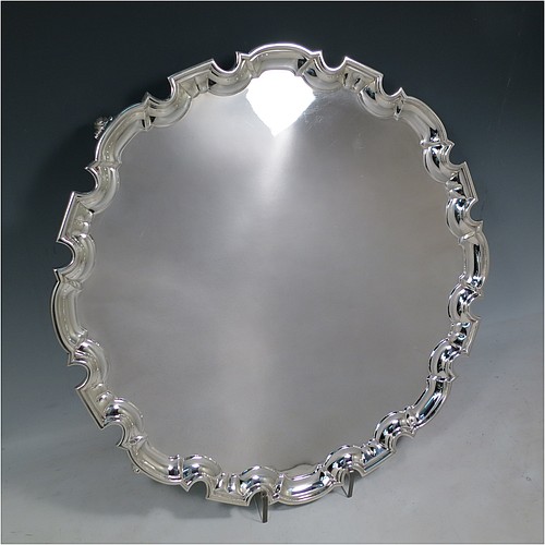 A large Sterling Silver salver, having a Chippendale border, a plain ground, and sitting on four cast scroll feet. Made by William Hutton of Sheffield in 1925. The dimensions of this fine hand-made large silver salver are diameter 44.5 cms (17.5 inches), and it weighs approx. 2,046g (66 troy ounces).    