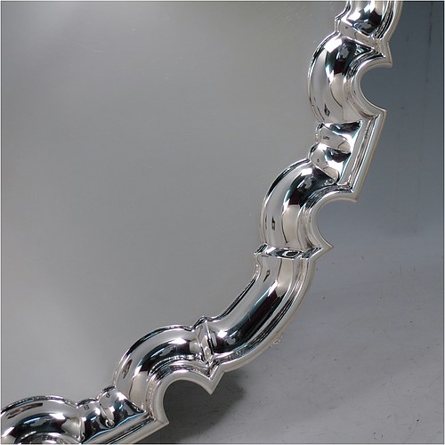A large Sterling Silver salver, having a Chippendale border, a plain ground, and sitting on four cast scroll feet. Made by William Hutton of Sheffield in 1925. The dimensions of this fine hand-made large silver salver are diameter 44.5 cms (17.5 inches), and it weighs approx. 2,046g (66 troy ounces).