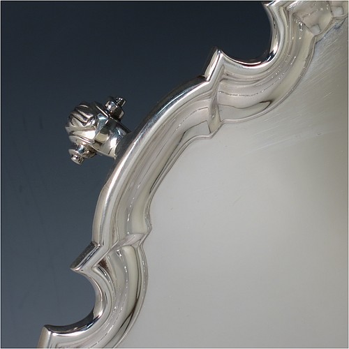 A large Sterling Silver salver, having a Chippendale border, a plain ground, and sitting on four cast scroll feet. Made by William Hutton of Sheffield in 1925. The dimensions of this fine hand-made large silver salver are diameter 44.5 cms (17.5 inches), and it weighs approx. 2,046g (66 troy ounces).