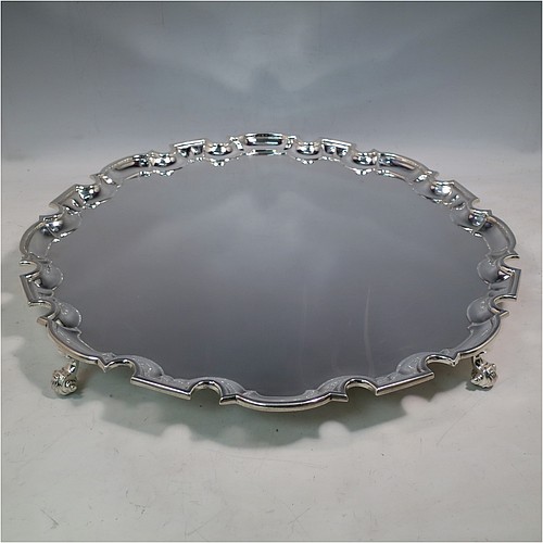 A large Sterling Silver salver, having a Chippendale border, a plain ground, and sitting on four cast scroll feet. Made by William Hutton of Sheffield in 1925. The dimensions of this fine hand-made large silver salver are diameter 44.5 cms (17.5 inches), and it weighs approx. 2,046g (66 troy ounces).