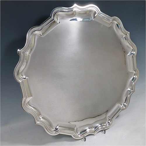 A large Antique Sterling Silver salver, having a round body, with a plain burnished ground, an applied Bath border, and sitting on four cast hoof feet. Made by Carrington and Co., of London in 1915. The dimensions of this fine hand-made antique silver salver are diameter 46 cms (18 inches), and it weighs approx. 2,388g (77 troy ounces).    
