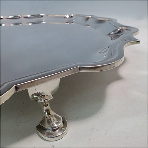 A large Antique Sterling Silver salver, having a round body, with a plain burnished ground, an applied Bath border, and sitting on four cast hoof feet. Made by Carrington and Co., of London in 1915. The dimensions of this fine hand-made antique silver salver are diameter 46 cms (18 inches), and it weighs approx. 2,388g (77 troy ounces).