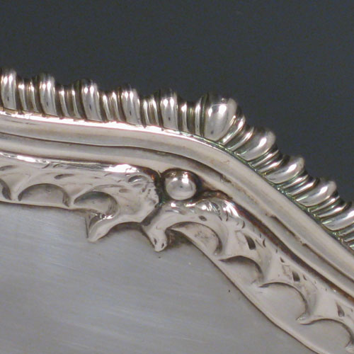 A handsome Antique Georgian Sterling Silver salver, having an applied shaped gadroon border with hand-chased anthemion leaves, a plain ground, and sitting on four cast claw and ball feet. This beautiful antique salver was made by Richard Rugg of London in 1768. The dimensions of this fine hand-made silver slaver are diameter 38 cms (15 inches), and it weighs approx. 1,368g (44 troy ounces).