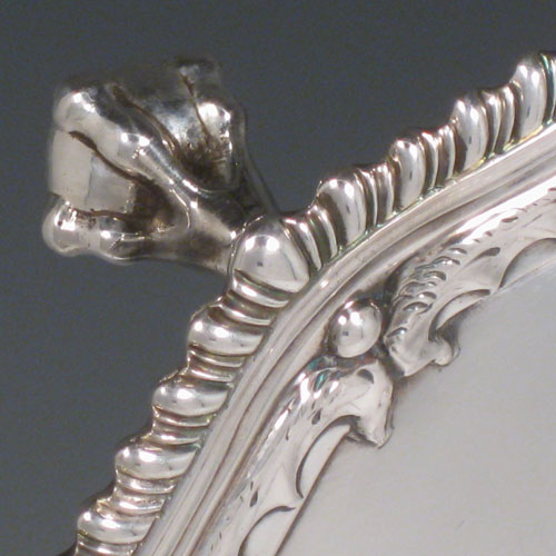 A handsome Antique Georgian Sterling Silver salver, having an applied shaped gadroon border with hand-chased anthemion leaves, a plain ground, and sitting on four cast claw and ball feet. This beautiful antique salver was made by Richard Rugg of London in 1768. The dimensions of this fine hand-made silver slaver are diameter 38 cms (15 inches), and it weighs approx. 1,368g (44 troy ounces).