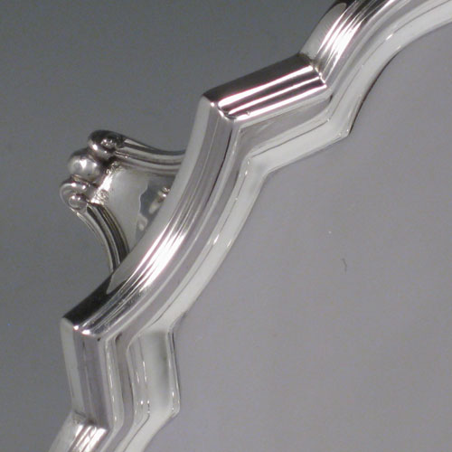 Sterling silver salver, having cut-corners with reeded borders, a plain ground, and sitting on four cast flange feet. Made by William Hutton and Sons of Sheffield in 1944. Dimensions 30 cms (12 inches) square. Weight approx. 1,082g (35 troy ounces).