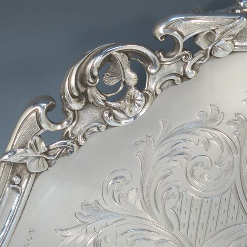 A very pretty Antique Victorian Silver Plated large salver, having an applied cast scroll border with floral decoration and piercing, with a ground having hand-engraved floral and scroll decoration surrounding a central vacant round cartouche, and all sitting on three cast scroll feet. Made (poss.) by James Dixon And Sons of Sheffield in ca. 1860. The dimensions of this fine hand-made antique silver-plated salver are diameter 48 cms (19 inches), and height 5 cms (2 inches).