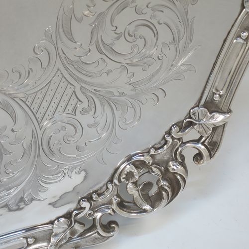 A very pretty Antique Victorian Silver Plated large salver, having an applied cast scroll border with floral decoration and piercing, with a ground having hand-engraved floral and scroll decoration surrounding a central vacant round cartouche, and all sitting on three cast scroll feet. Made (poss.) by James Dixon And Sons of Sheffield in ca. 1860. The dimensions of this fine hand-made antique silver-plated salver are diameter 48 cms (19 inches), and height 5 cms (2 inches).