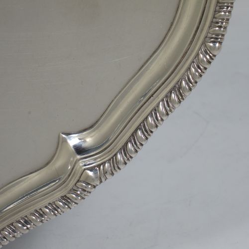 A very handsome Antique Georgian Sterling Silver salver, having an applied shaped gadroon border, a plain ground with a hand-engraved armorial central crest, and sitting on four cast claw and ball feet. This beautiful antique silver salver was made by John Carter II of London in 1772. The dimensions of this fine hand-made antique silver salver are diameter 35 cms (13.75 inches), and it weighs approx. 1,270g (41 troy ounces).