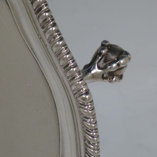 A very handsome Antique Georgian Sterling Silver salver, having an applied shaped gadroon border, a plain ground with a hand-engraved armorial central crest, and sitting on four cast claw and ball feet. This beautiful antique silver salver was made by John Carter II of London in 1772. The dimensions of this fine hand-made antique silver salver are diameter 35 cms (13.75 inches), and it weighs approx. 1,270g (41 troy ounces).