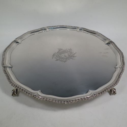 A very handsome Antique Georgian Sterling Silver salver, having an applied shaped gadroon border, a plain ground with a hand-engraved armorial central crest, and sitting on four cast claw and ball feet. This beautiful antique silver salver was made by John Carter II of London in 1772. The dimensions of this fine hand-made antique silver salver are diameter 35 cms (13.75 inches), and it weighs approx. 1,270g (41 troy ounces).