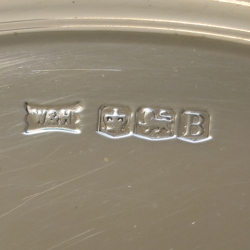 A very handsome and striking Art Deco Sterling Silver salver, having an octagonal body with an applied straight gadroon border, with a plain burnished and recessed ground, and sitting on four cast flange feet. Made by Walker and Hall of Sheffield in 1944. The dimensions of this fine hand-made Art Deco style silver salver are 32 cms (12.5 inches) diameter, and it weighs approx. 930g (30 troy ounces).