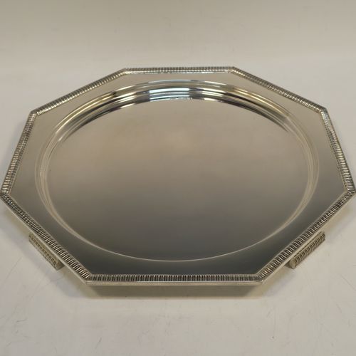 A very handsome and striking Art Deco Sterling Silver salver, having an octagonal body with an applied straight gadroon border, with a plain burnished and recessed ground, and sitting on four cast flange feet. Made by Walker and Hall of Sheffield in 1944. The dimensions of this fine hand-made Art Deco style silver salver are 32 cms (12.5 inches) diameter, and it weighs approx. 930g (30 troy ounces).