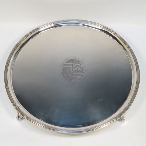 A large and very handsome Antique Georgian Sterling Silver salver, having a round body with an applied reeded border, a plain ground with a hand-engraved full armorial central crest, and sitting on four cast reeded and flanged feet. This elegant antique silver salver was made by Charles Hougham of London in 1790. The dimensions of this fine hand-made antique silver salver are diameter 38 cms (15 inches), and it weighs approx. 1,440g (46.5 troy ounces).