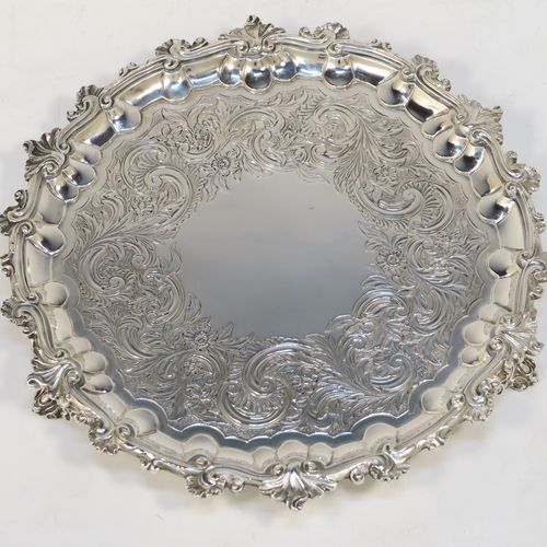 A beautiful Antique Georgian (William IV) Sterling Silver salver, having a hand-chased ground with floral and scroll decoration, an applied cast shell and scroll border and sitting on three cast foliate  feet. This pretty antique silver salver was made by the Barnard Brothers of London in 1835. The dimensions of this fine hand-made silver salver are diameter 24 cms (9.5 inches), and it weighs approx. 478g (15.4 troy ounces).  