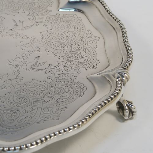A very pretty Antique Victorian Sterling Silver salver, having an applied and shaped bead-edged border, a hand-engraved ground with floral, scroll, and bird decoration, and sitting on three cast claw and ball feet. This beautiful antique silver salver was made by Stephen Smith of London in 1876. The dimensions of this fine hand-made silver salver are diameter 27.5 cms (10.75 inches), and it weighs approx. 792g (25.5 troy ounces).