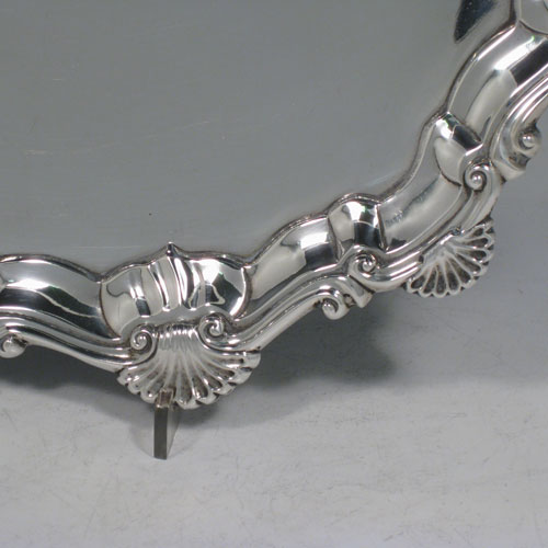 Antique Georgian sterling silver salver, having a shell and scroll border, a plain ground, and sitting on three cast hoof feet. Made by Ebenezer Coker of London in 1768. The dimensions of this fine hand-made silver salver are diameter 29 cms (11.5 inches), and it weighs approx. 688g (22 troy ounces).