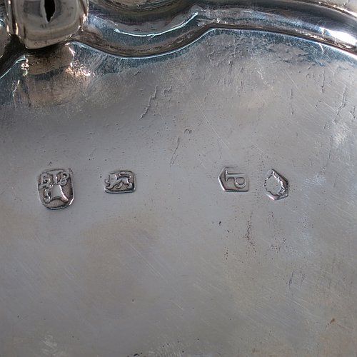 An Antique Georgian Sterling Silver George II salver, having a Chippendale border, a plain ground, and sitting on four cast scroll feet. Made by John Tuite of London in 1730. The dimensions of this fine hand-made antique silver salver are diameter 26.5 cms (10.25 inches), and it weighs approx. 491g (15.8 troy ounces).    