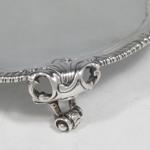 Antique Georgian sterling silver pair of George III salvers, having plain grounds, cast applied shaped gadroon and floral borders, and sitting on three cast and pierced foliate feet. Made by John Harvery I (possibly) of London in 1763 <a href=http://en.wikipedia.org/wiki/1763>(see what happened in this year).</a> The dimensions of these fine hand-made silver salvers are diameter 21 cms (8.25 inches), and they weigh approx. 789g (25.5 troy ounces).