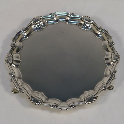 A very elegant pair of Antique Georgian Sterling Silver George II salvers, having plain grounds with applied shaped gadroon and scroll borders, and sitting on three cast hoof feet. These beautiful antique silver salvers were made by John Tuite of London in 1750. The dimensions of these fine hand-made antique Goerge II silver salvers are diameter 17 cms (6.75 inches), and they weigh approx. 475g (15.3 troy ounces).