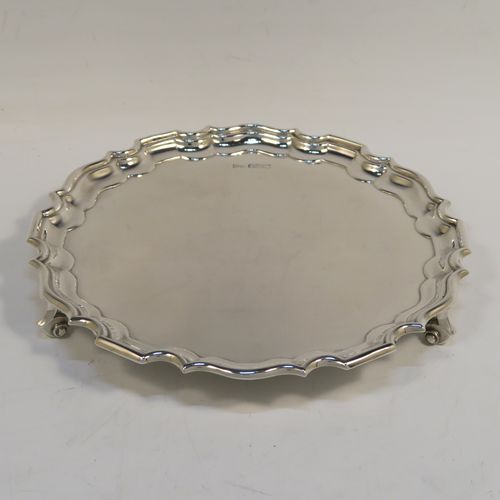 A handsome Antique Sterling Silver round salver, having a plain burnished ground, an applied Chippendale border, and sitting on three cast scroll feet. This elegant silver salver was made by Walker and Hall of Sheffield in 1924. The dimensions of this fine hand-made antique silver salver are diameter 20 cms (8 inches), and it weighs approx. 319g (10.3 troy ounces).