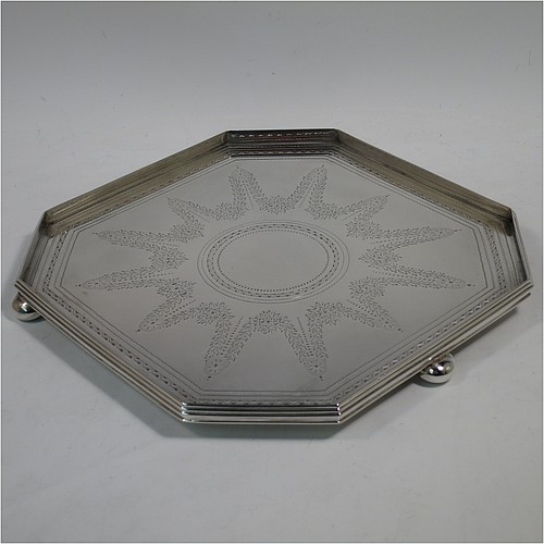 A very handsome and unusual Antique Victorian Sterling silver salver, having an octagonal body, a hand-engraved ground with floral swags and bands of bright-cut decoration, an applied reeded gallery border, and sitting on three cast cushion ball feet. Made by the Barnard Brothers of London in 1897. The dimensions of this fine hand-made antique salver are 21 cms (8.25 inches) square, height 2.5 cms (1 inch), and it weighs approx. 574g (18.5 troy ounces).
