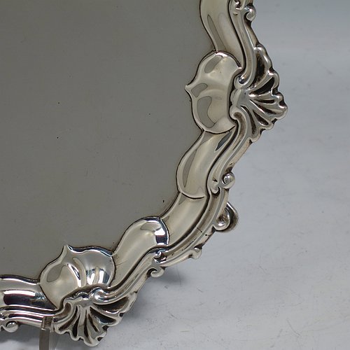 An Antique Georgian Sterling Silver salver, having a plain burnished ground, an applied shell and scroll border, and sitting on three cast hoof feet. Made by James Wilks of London in 1752. The dimensions of this fine hand-made antique silver salver are diameter 19 cms (7.55 inches), and it weighs approx. 262g (8.5 troy ounces).