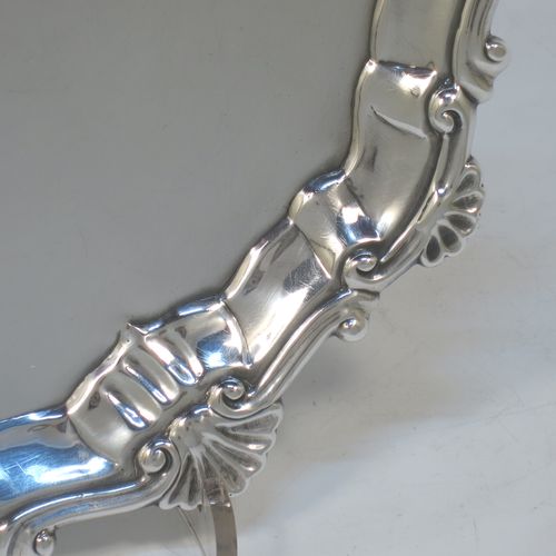 A very elegant Antique Georgian Sterling Silver salver, having a plain burnished ground, an applied shell and scroll border, and sitting on three cast hoof feet. Made by Ebenezer Coker of London in 1767. The dimensions of this fine hand-made antique silver salver are diameter 21 cms (8.5 inches), and it weighs approx. 310g (10 troy ounces).