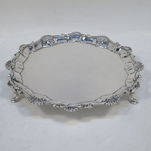 A very elegant Antique Georgian Sterling Silver salver, having a plain burnished ground, an applied shell and scroll border, and sitting on three cast hoof feet. Made by Ebenezer Coker of London in 1767. The dimensions of this fine hand-made antique silver salver are diameter 21 cms (8.5 inches), and it weighs approx. 310g (10 troy ounces).