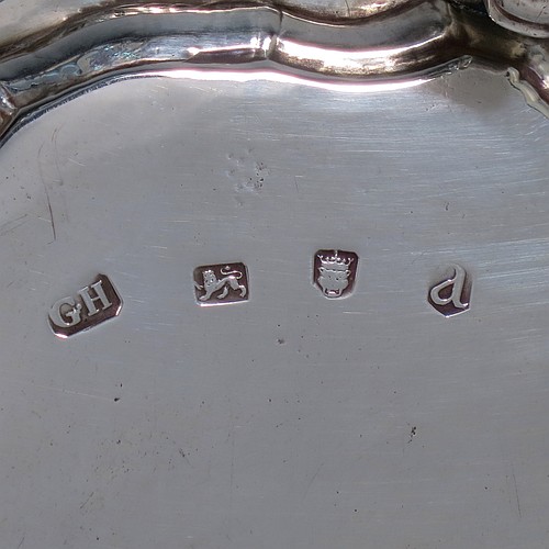 An Antique Georgian Sterling Silver George II round salver, having a plain burnished ground, an applied Chippendale border, and sitting on three cast hoof feet. Made by George Hindmarsh of London in 1736. The dimensions of this fine hand-made antique silver salver are diameter 15.5 cms (6 inches), and it weighs approx. 209g (6.7 troy ounces).
