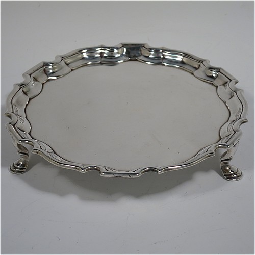 An Antique Georgian Sterling Silver George II round salver, having a plain burnished ground, an applied Chippendale border, and sitting on three cast hoof feet. Made by George Hindmarsh of London in 1736. The dimensions of this fine hand-made antique silver salver are diameter 15.5 cms (6 inches), and it weighs approx. 209g (6.7 troy ounces).