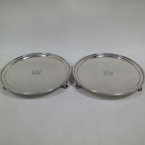 A very handsome Antique Georgian Sterling Silver pair of salvers, having applied reeded borders, plain grounds with hand-engraved central crests, and sitting on three cast reeded flange feet. Made by John Schofiled of London in 1784. The dimensions of these fine hand-made antique silver pair of salvers are diameter 19 cms (7.5 inches), and they weigh a total of approx. 682g (22 troy ounces).