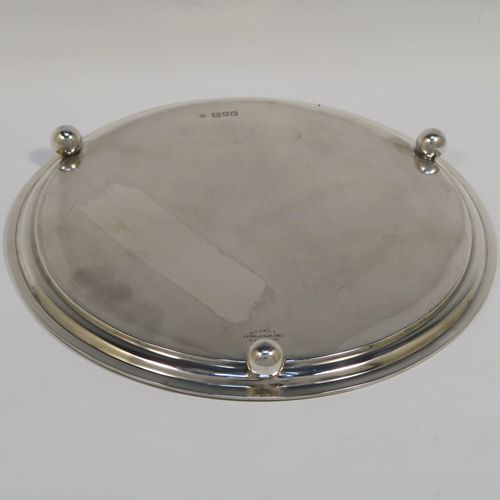 A heavy and very elegant Georgian style Antique Sterling Silver salver, having a plain ground, with an applied reeded border, and all sitting on three cast ball feet. This handsome antique silver salver was made by Herbert Lambert of London in 1912. The dimensions of this fine hand-made silver salver are diameter 23 cms (9 inches), and it weighs approx. 574g (18.5 troy ounces).