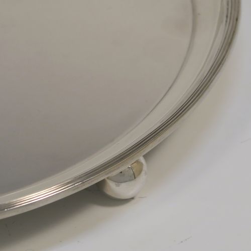 A heavy and very elegant Georgian style Antique Sterling Silver salver, having a plain ground, with an applied reeded border, and all sitting on three cast ball feet. This handsome antique silver salver was made by Herbert Lambert of London in 1912. The dimensions of this fine hand-made silver salver are diameter 23 cms (9 inches), and it weighs approx. 574g (18.5 troy ounces).