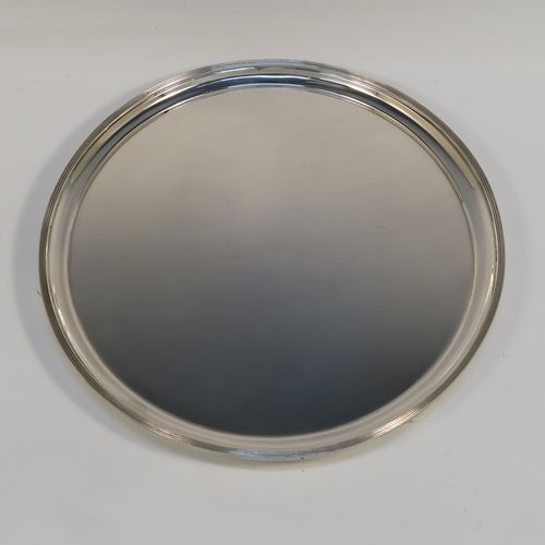 A heavy and very elegant Georgian style Antique Sterling Silver salver, having a plain ground, with an applied reeded border, and all sitting on three cast ball feet. This handsome antique silver salver was made by Herbert Lambert of London in 1912. The dimensions of this fine hand-made silver salver are diameter 23 cms (9 inches), and it weighs approx. 574g (18.5 troy ounces).