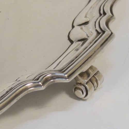 An elegant Sterling Silver round salver, having a plain burnished ground, an applied Chippendale border, and sitting on three cast scroll feet. This handsome silver salver was made by the Barker Brothers of Birmingham in 1923. The dimensions of this fine hand-made silver salver are diameter 20 cms (8 inches), and it weighs approx. 350g (11.3 troy ounces).