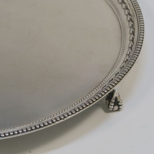 A very pretty Sterling Silver salver, having an applied bead-edged border above a hand-chased floral band, a plain ground, and sitting on three cast claw and ball feet. This beautiful silver salver was made by James Dixon and Sons of Sheffield in 1929. The dimensions of this fine hand-made silver salver are diameter 20 cms (8 inches), and it weighs approx. 307g (9.9 troy ounces).
