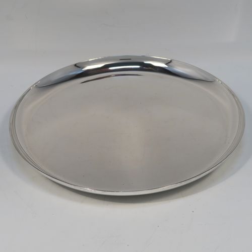 A very handsome Antique Sterling Silver salver, having a round body with a plain burnished ground, a raised border, and sitting on three cast flange feet. This elegant silver salver was made by William Bruford and Sons of London in 1922. The dimensions of this fine hand-made antique silver salver are diameter 20 cms (8 inches), height 2 cms (1 inch), and it weighs approx. 500gg (16 troy ounces).   