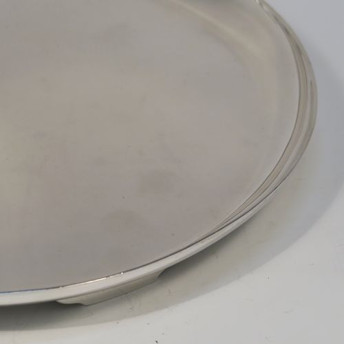 A very handsome Antique Sterling Silver salver, having a round body with a plain burnished ground, a raised border, and sitting on three cast flange feet. This elegant silver salver was made by William Bruford and Sons of London in 1922. The dimensions of this fine hand-made antique silver salver are diameter 20 cms (8 inches), height 2 cms (1 inch), and it weighs approx. 500gg (16 troy ounces).