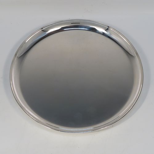 A very handsome Antique Sterling Silver salver, having a round body with a plain burnished ground, a raised border, and sitting on three cast flange feet. This elegant silver salver was made by William Bruford and Sons of London in 1922. The dimensions of this fine hand-made antique silver salver are diameter 20 cms (8 inches), height 2 cms (1 inch), and it weighs approx. 500gg (16 troy ounces).
